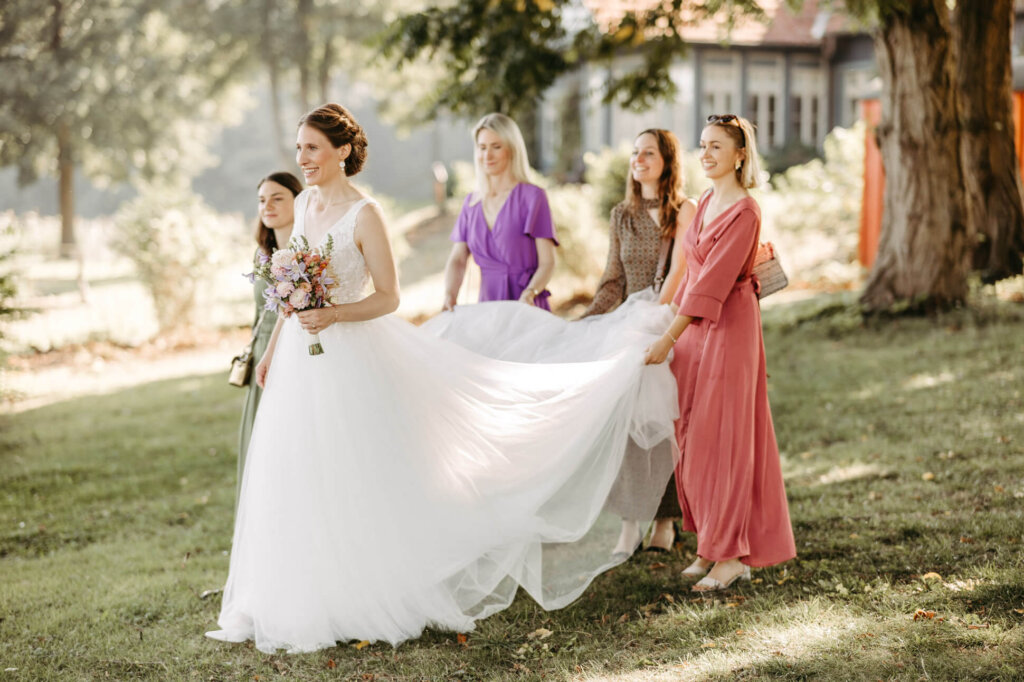 Braut umringt von ihren Trauzeuginnen auf dem Weg zum First Look