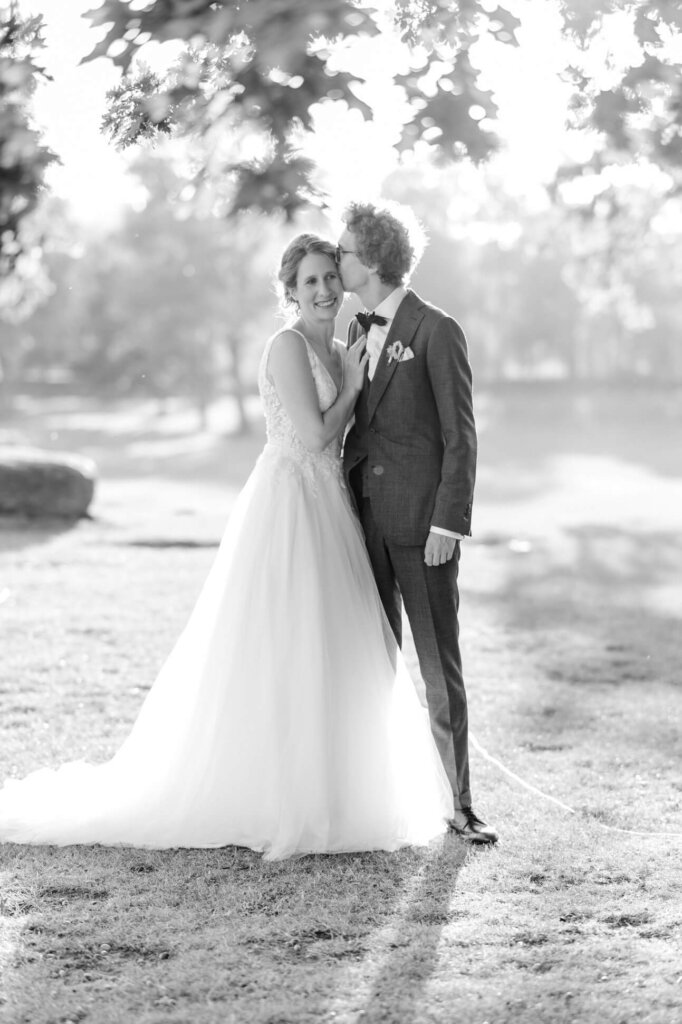 Brautpaar in der Abendsonne, er küsst sie auf die Schläfe