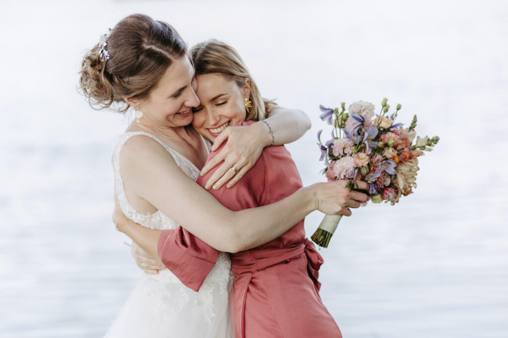 Innige Umarmung von Braut und Trauzeugin