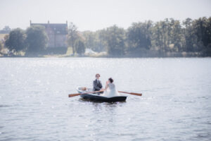 Das Hochzeitspaar rudert über den Ulrichshusener See zum Schloss