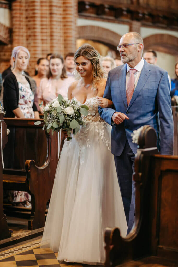 Braut beim Einlaufen in die Kirche mit ihrem Vater in Luckenwalde