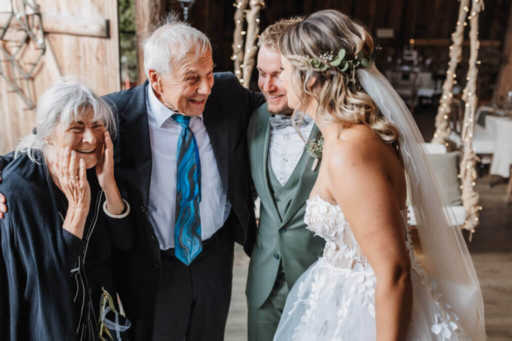 Das Brautpaar in inniger Geste mit den Großeltern