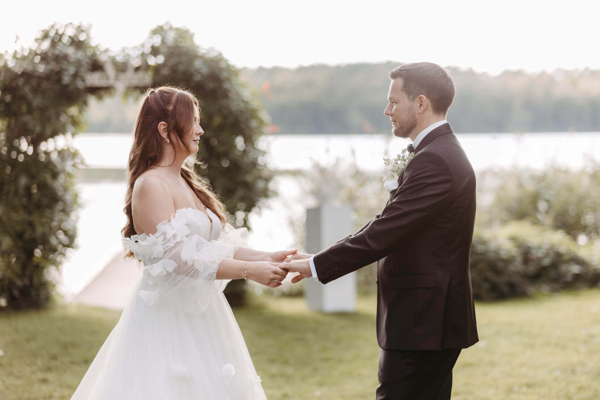 Brautpaar tanzt im Sonnenlicht auf der Wiese in Brandenburg, Villa Zesch am See und hält sich dabei an den Händen