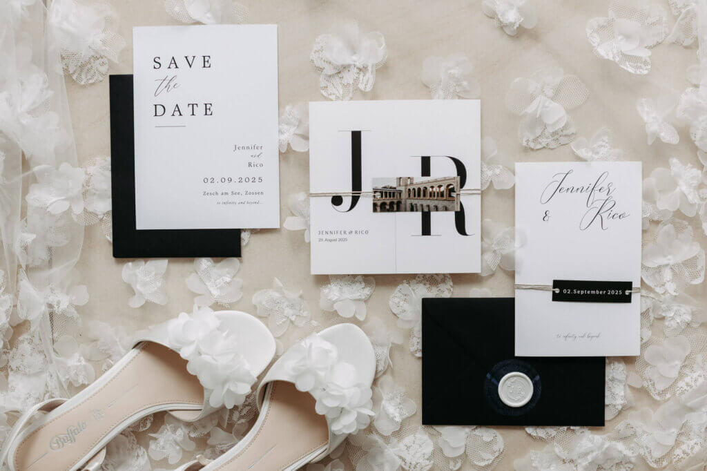 Flatlay mit Brautschleier, Brautschuhen, Papeterie in Cremetönen