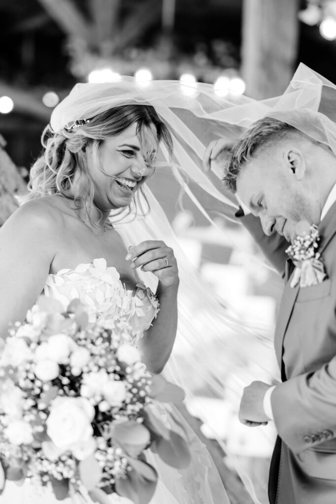 Lachendes Brautpaar in schwarz weiß