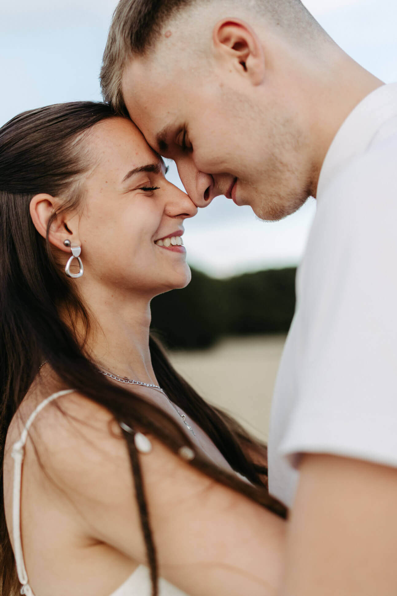 Portraitaufnahme eines verliebten Pärchens das Stirn an Stirn steht und sich anlächelt in Ueckermünde