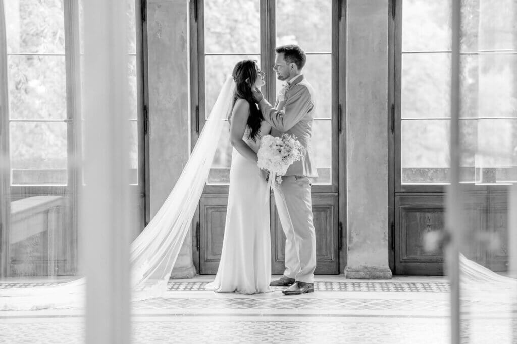 Hochzeitspaar schaut sich verliebt an vor großem Fenster, fotografiert von der Hochzeitsfotografin Potsdam