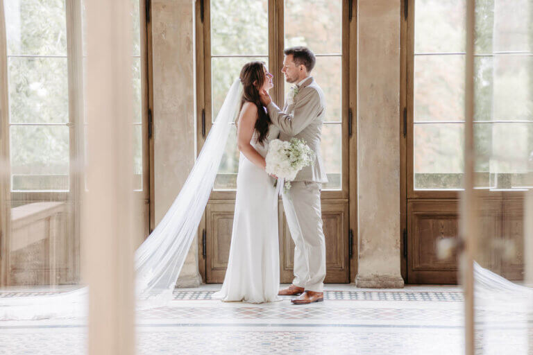 Brautpaar vor großer Fensterfront im Belvedere Pfingstberg Potsdam, schaut sich in die Augen