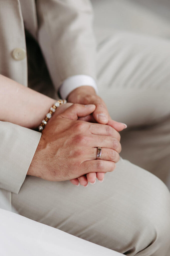 Die Hände des Brautpaares ineinander verschränkt