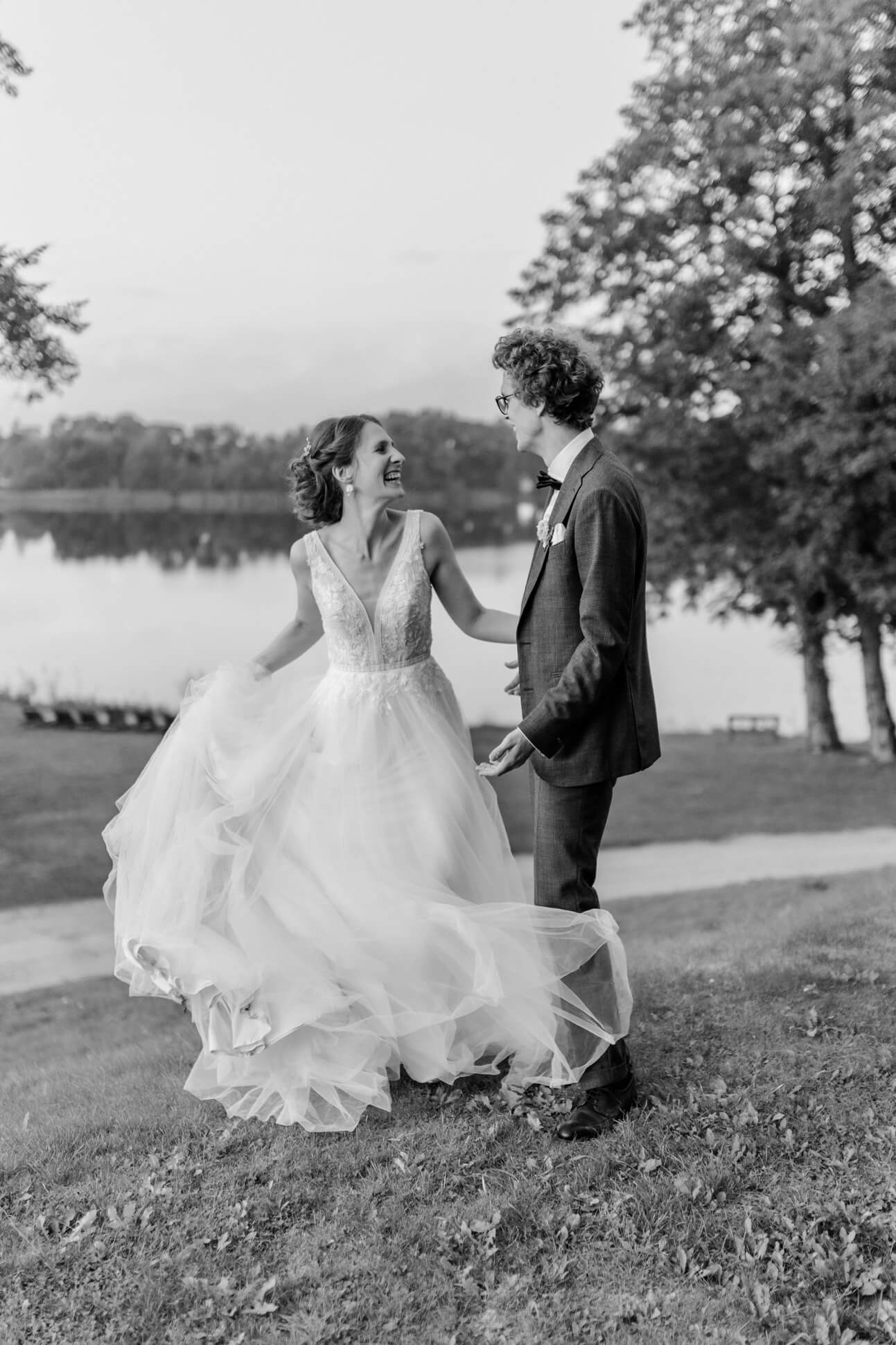 Braut und Bräutigam tanzen ausgelassen über die Wiese