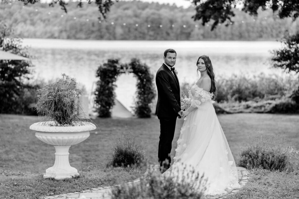 Hochzeitspaar steht in mediterranem Ambiente und schaut in die Kamera