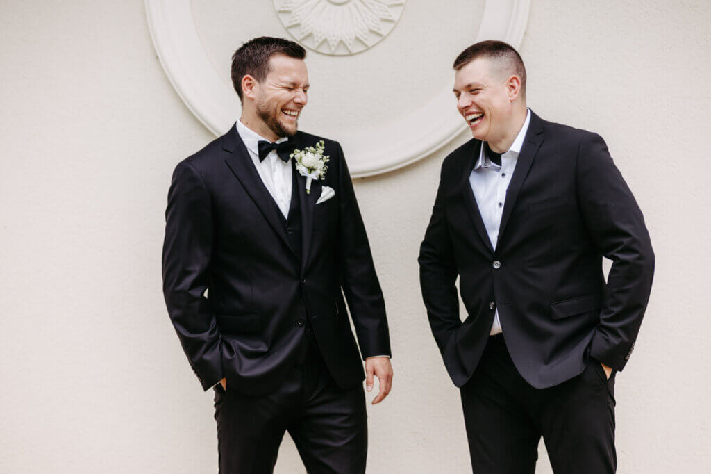 Bräutigam und Trauzeuge lachend beim Getting Ready