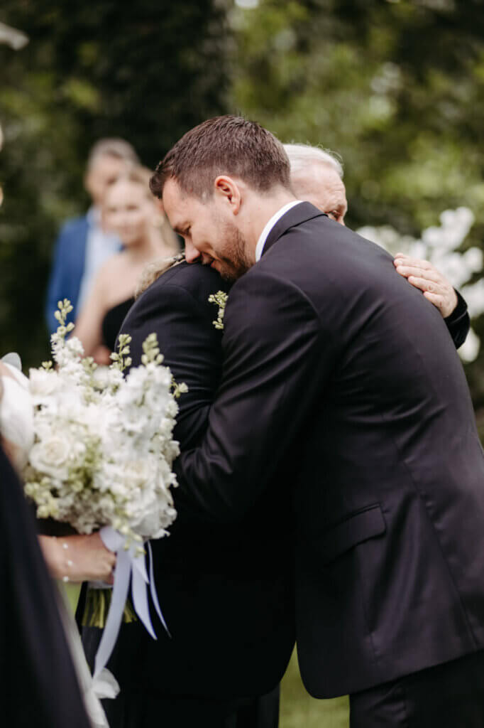 Umarmung von Bräutigam und Brautvater bei der Übergabe der Braut