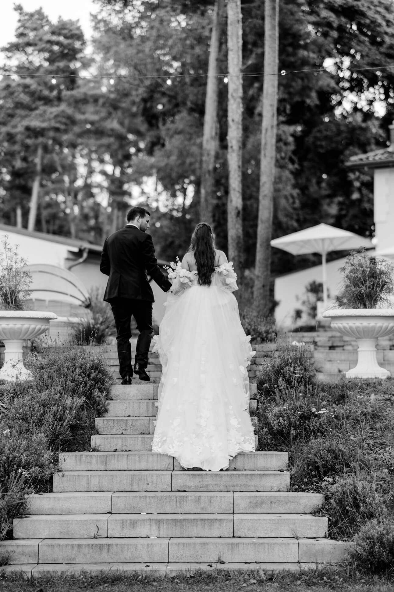 Das Brautpaar von hinten auf den Treppen der Villa Zesch