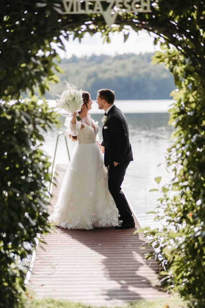 Das Brautpaar tanzt beim Paarshooting mit der Hochzeitsfotografin Brandenburg auf dem Steg