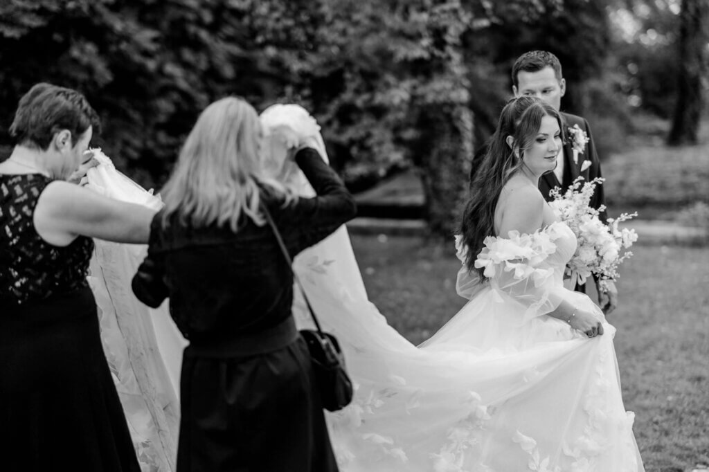 Die Großeltern tragen die Schleppe der Braut