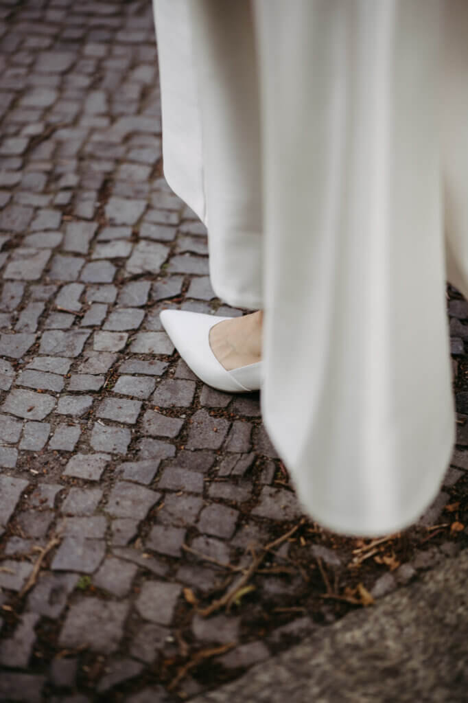 Nahaufnahme der Brautschuhe auf Berliner Pflaster