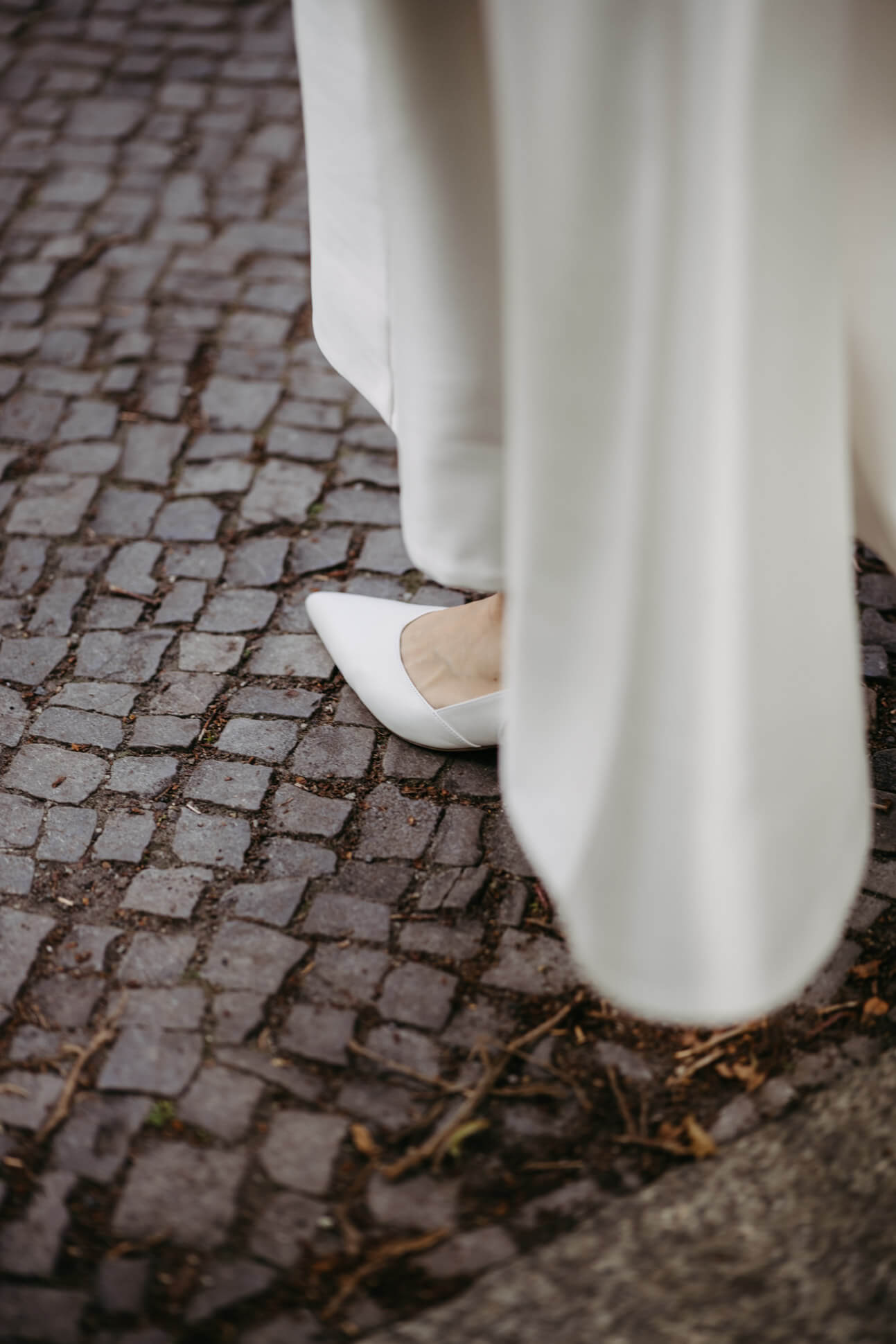Nahaufnahme der Brautschuhe auf Berliner Pflaster