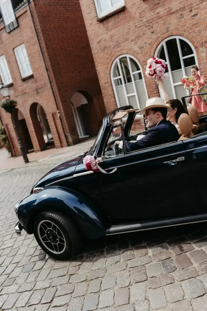 Brautpaar im Oldtimer Käfer nach der Trauung Lütjenburg